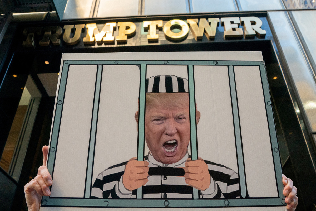 Протестующий, призывающий к аресту Трампа, возле башни Трампа в Нью-Йорке, 9 августа 2022 года