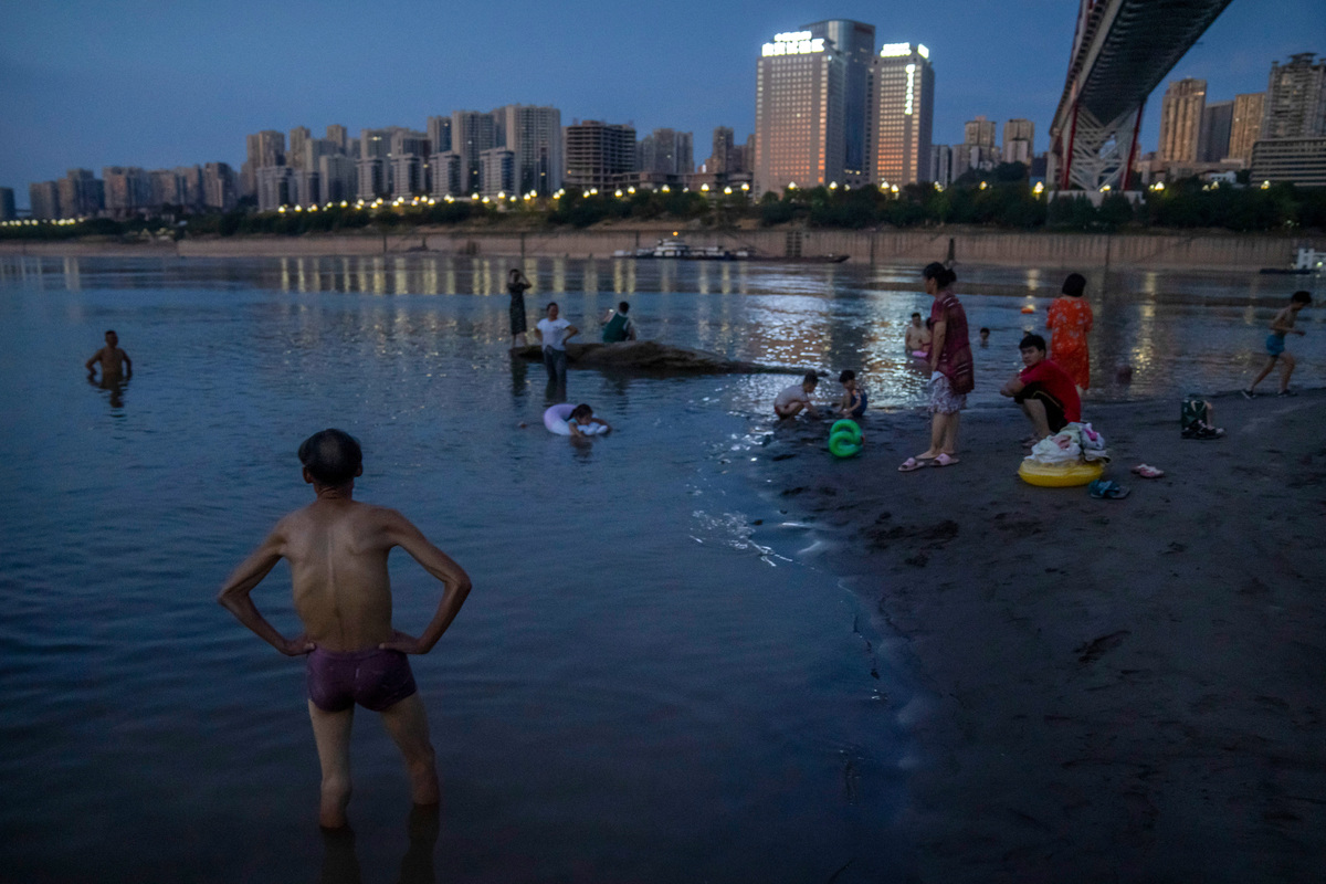 Люди купаются на мелководье реки Янцзы в муниципалитете Чунцин