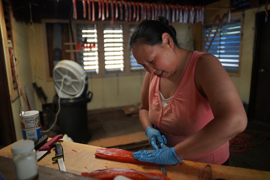 Бетти Джин Саттерликт нарезает и солит лосося в семейном кемпинге на берегу Колумбии, 21 июня 2022 года