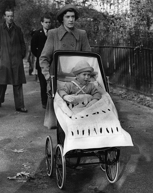 Принц Чарльз в коляске во время прогулки в лондонском парке, 1950 год