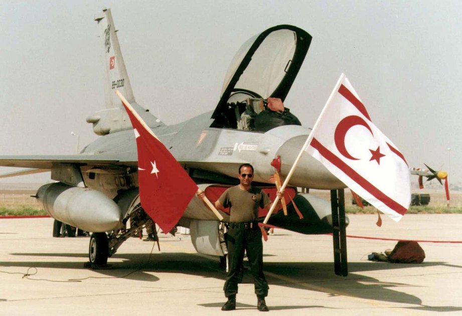 Пилот F-16 машет флагами Турции и ТРСК перед своим самолетом на летном поле аэропорта в Гечиткале на Северном Кипре