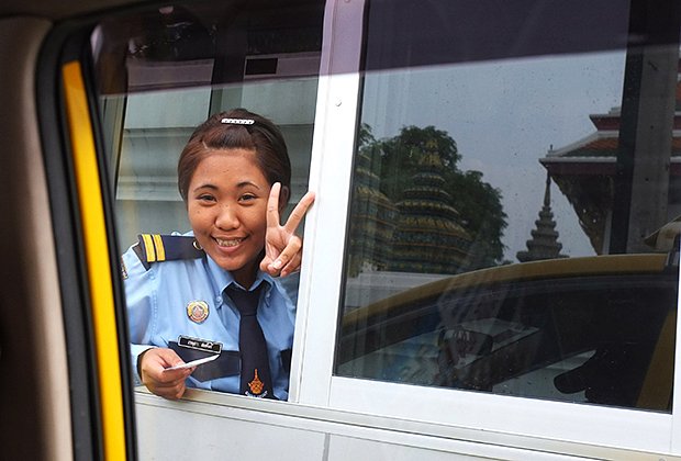 Сотрудница парковки в Таиланде приветствует посетителей