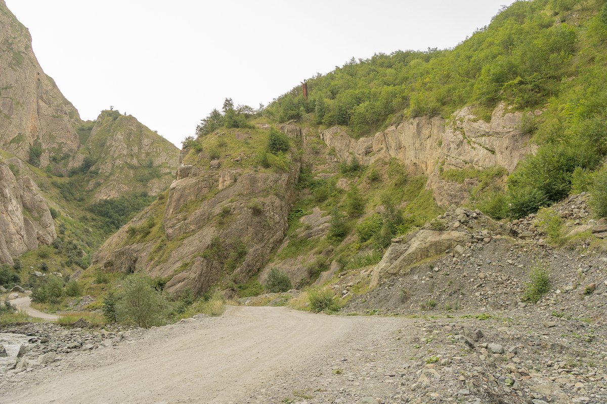 Дорога через Кармадонскую теснину, над которой заметен обрезок трубы, пробитой отрядом поисковиков в тоннель