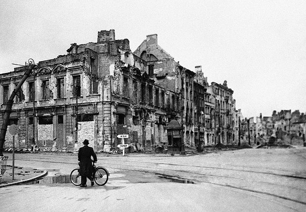 Одинокий велосипедист смотрит на панораму масштабных разрушений в Варшаве, 1 октября 1945 года