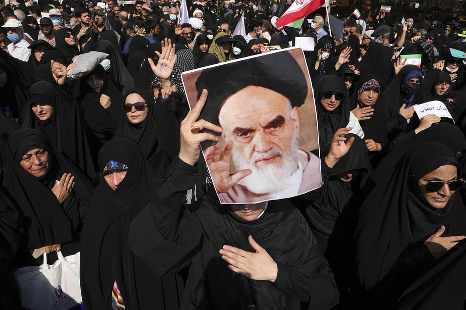 Проправительственный демонстрант держит плакат с изображением покойного аятоллы Хомейни во время митинга после пятничной молитвы в Тегеране, 23 сентября 2022 года