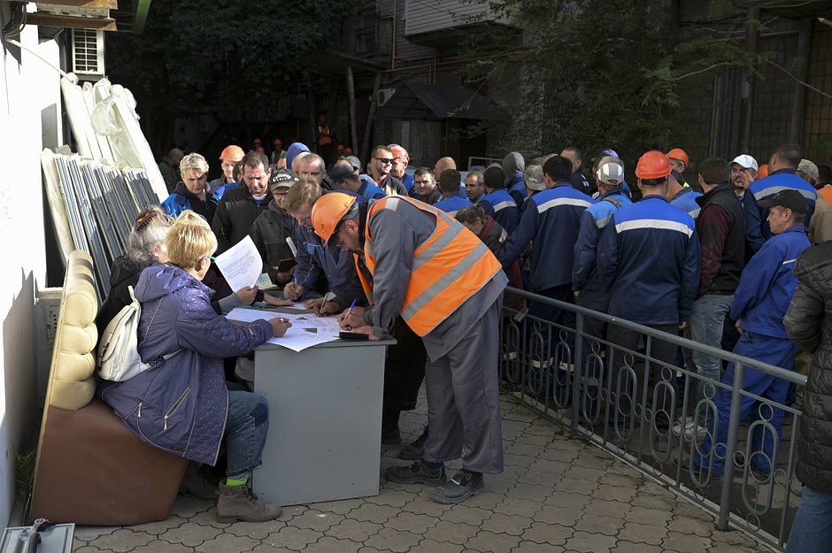 Очередь строителей за бюллетенями для голосования во время референдума на передвижном избирательном участке в Мариуполе, ДНР, 23 сентября 2022 года