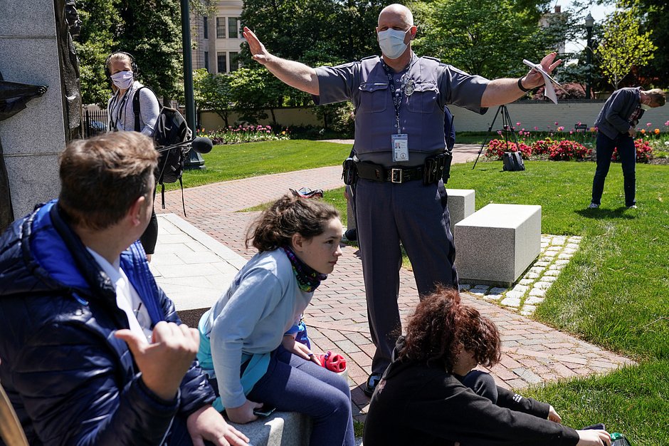 Полицейский просит демонстрантов сохранять социальную дистанцию на митинге против локдауна в Ричмонде, штат Вирджиния, 16 апреля 2020 года