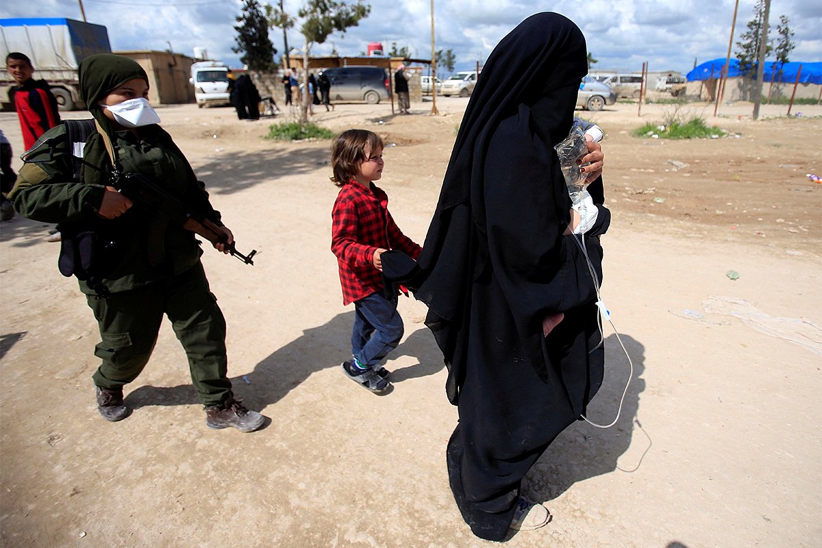 Боец SDF с женой боевика ИГ и ее детьми в лагере «Аль-Холь»