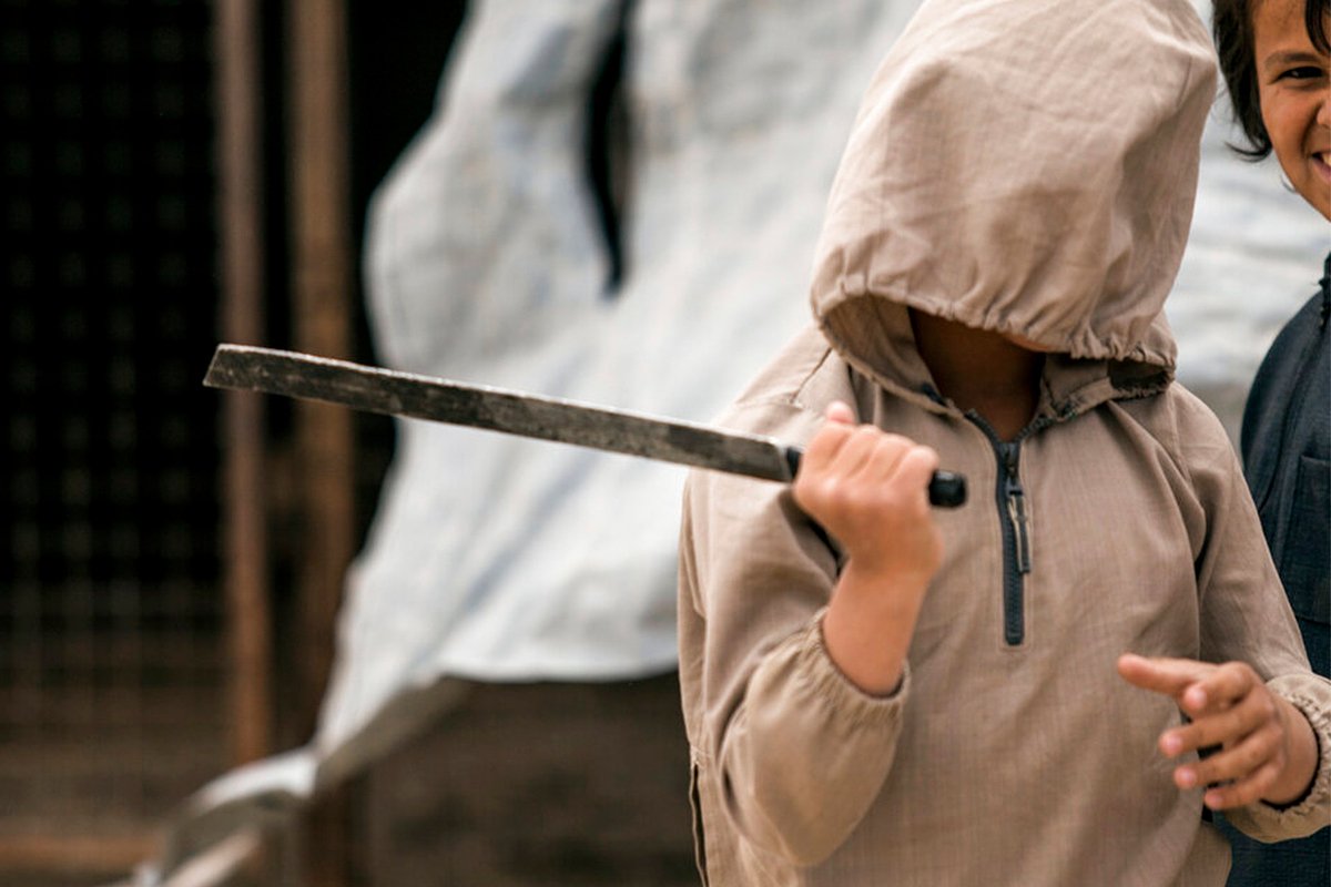Мальчик играет со сломанным мечом в лагере «Аль-Холь»