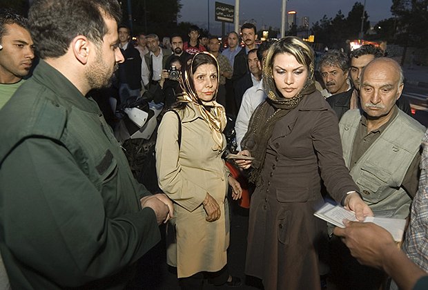 Полицейский проверяет документы иранки, чей наряд нарушает правила шариата