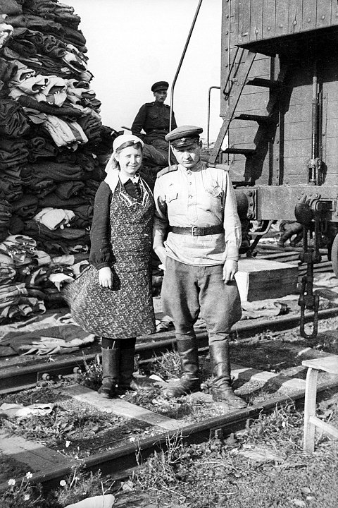 Ефрейтор Красной армии и учетчица возле товарного вагона с американскими вещами, поставленными по ленд-лизу. Чехия, 1945 год