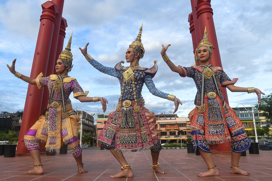 Участницы фестиваля тайского танца репетируют выступление возле храма Ват Сутхат Тепварарам в Бангкоке, Таиланд