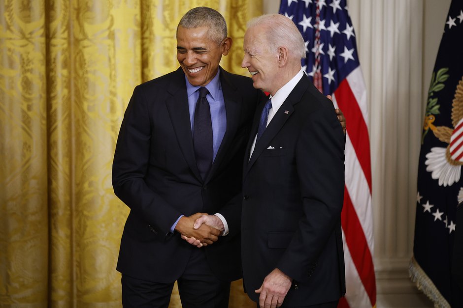 Бывший президент Барак Обама (слева) и президент США Джо Байден обмениваются рукопожатием во время мероприятия, посвященного принятию Закона о доступном медицинском обслуживании. Восточный зал Белого дома, 5 апреля 2022 года, Вашингтон