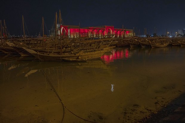 Традиционные лодки доу встречают туристов, подлетающих к Дохе, яркими огнями. Фото: Nariman El-Mofty / AP