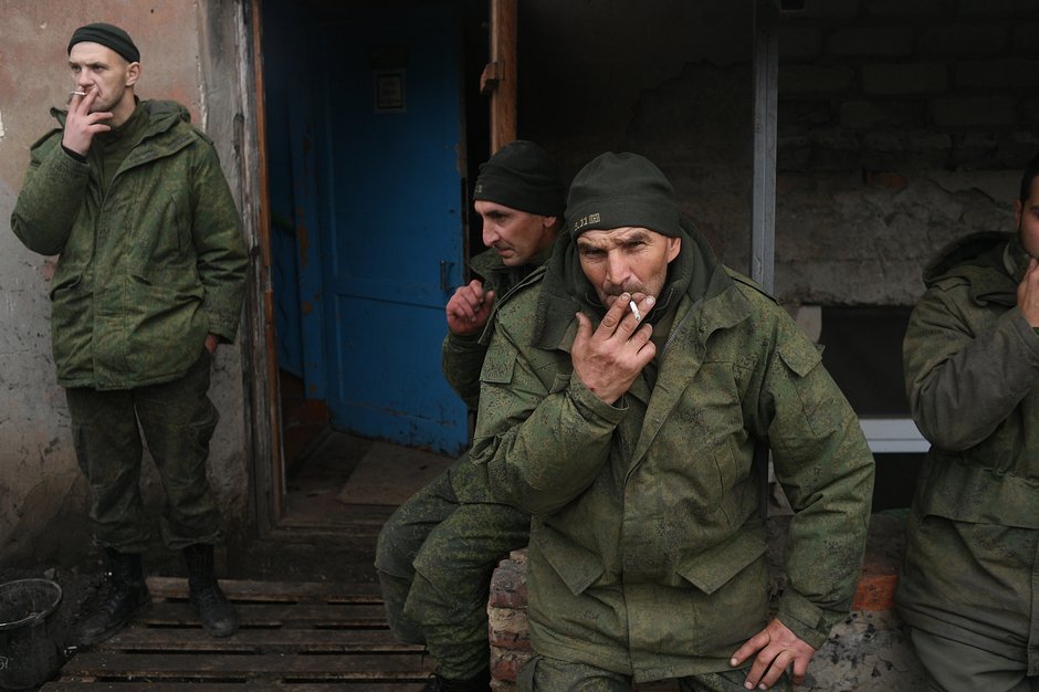 Бойцы курят после разгрузки грузовика с гуманитарной помощью в городе Ясиноватая в ДНР