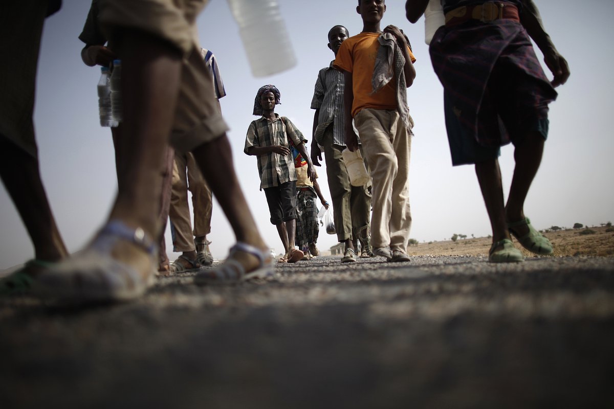 Эфиопские мигранты идут по обочине шоссе, ведущего в западный йеменский город Харад на границе с Саудовской Аравией, 28 марта 2012 года