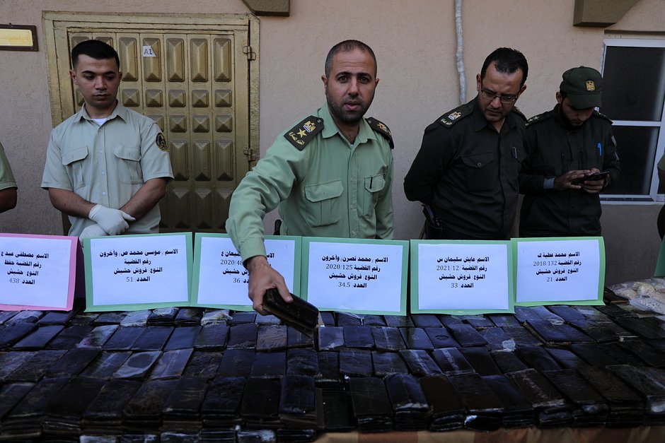 Силы безопасности ХАМАС охраняют выставку гашиша, марихуаны и таблеток трамадола, изъятых пограничниками. Газа, 21 октября 2021 года