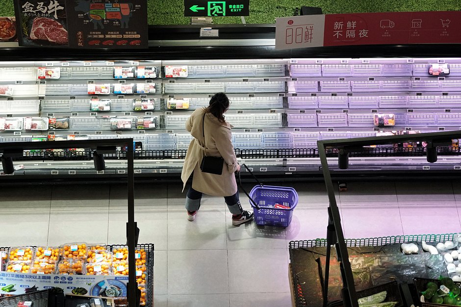 Покупатель выбирает продукты, выставленные на полках в супермаркете в Шанхае, 30 ноября 2022 года