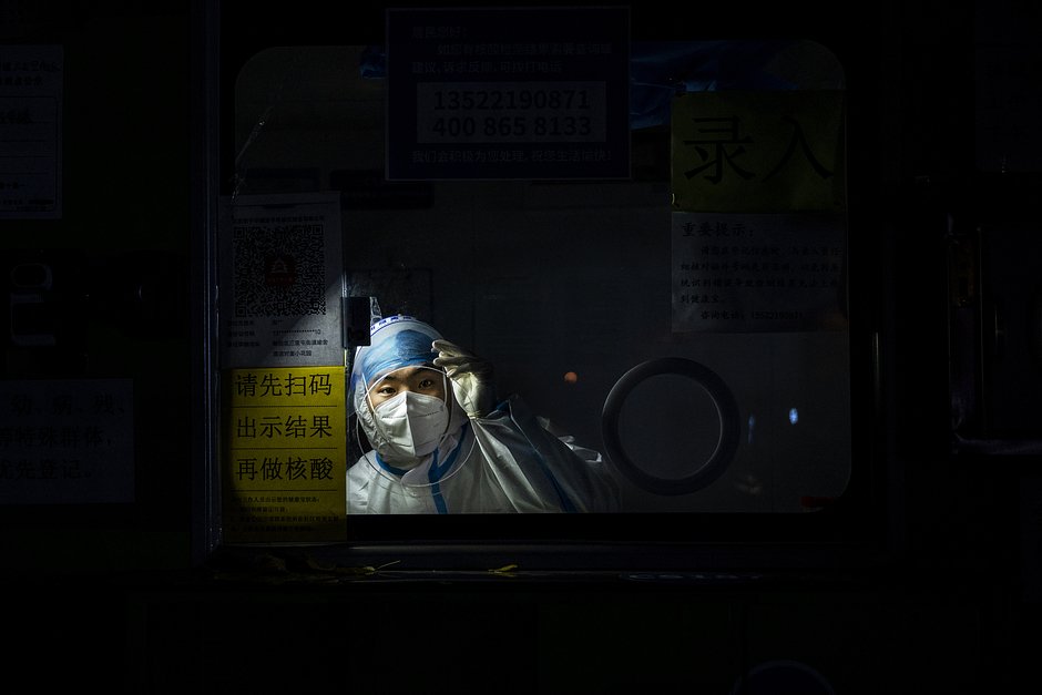 Медик в защитном костюме ждет в кабинке для проведения тестов на нуклеиновые кислоты для выявления COVID-19, 24 ноября 2022 года, Пекин