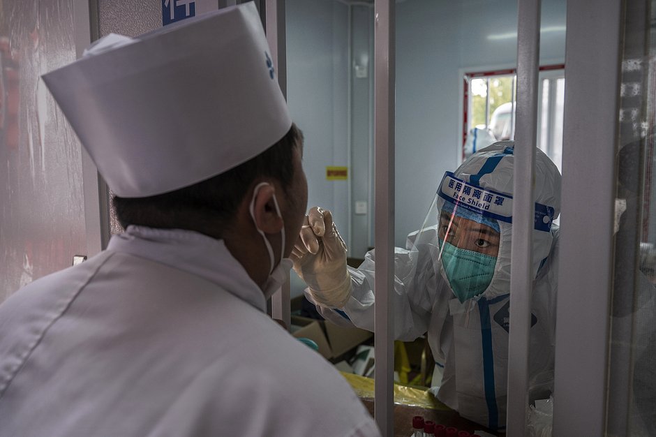 Медицинский сотрудник во время 20-го Национального конгресса Коммунистической партии Китая тестирует повара на нуклеиновую кислоту для выявления COVID-19, 20 октября 2022 года, Пекин