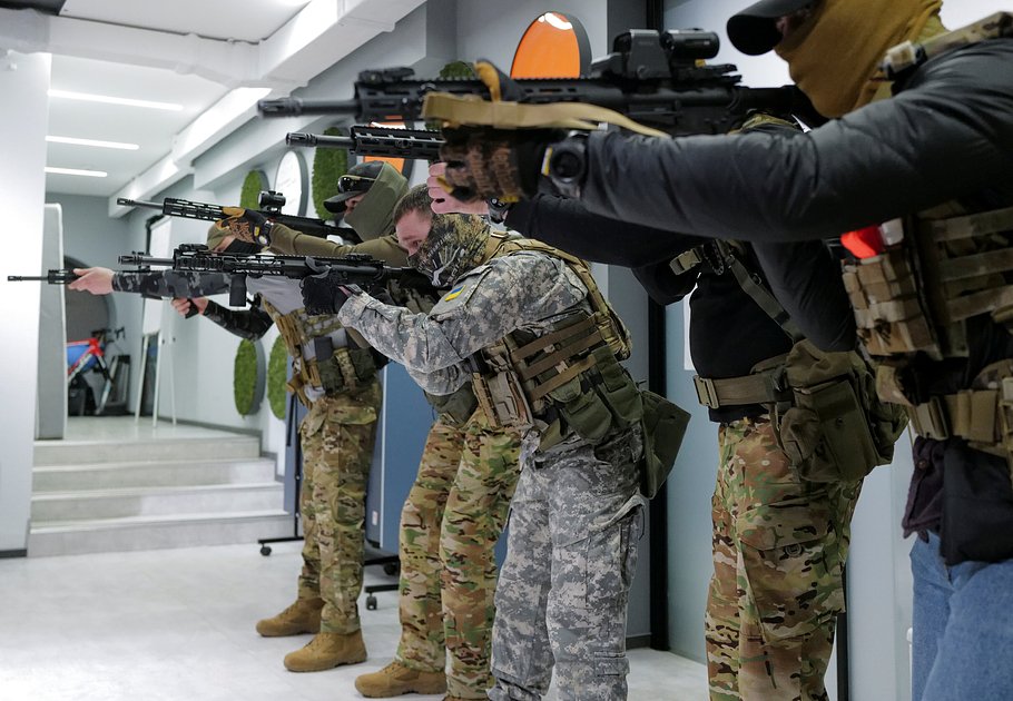 Добровольцы территориальной обороны тренируются с оружием в помещении частной компании во Львове, 23 марта 2022 года