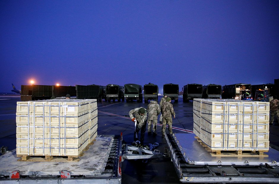 Украинские военнослужащие разгружают партию военной помощи, доставленной из США, в международном аэропорту Борисполь под Киевом