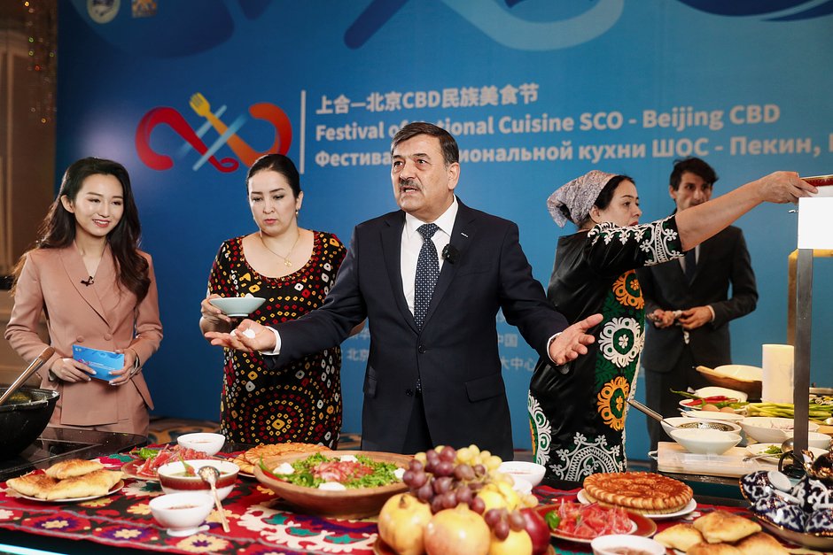 Саидзод Зохир Озод (в центре), чрезвычайный и полномочный посол Таджикистана в Китае, представляет таджикские блюда во время фестиваля национальной кухни ШОС, Пекин, Китая 10 октября 2021 года