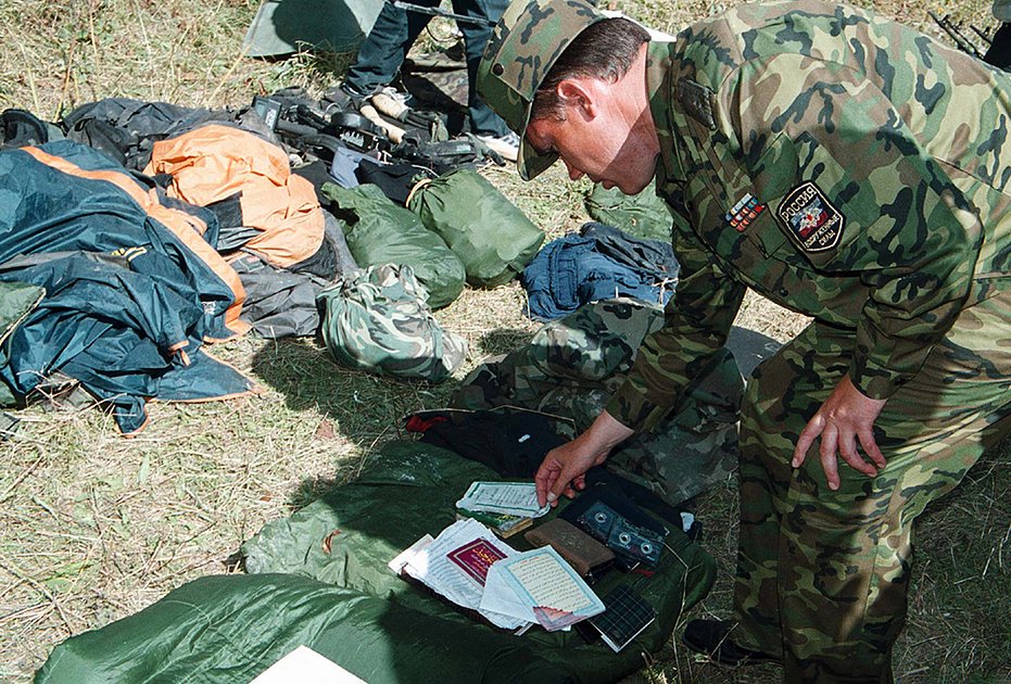 Командующий 58-й армией Валерий Герасимов рассматривает вещи убитых боевиков. 27 сентября 2002 года