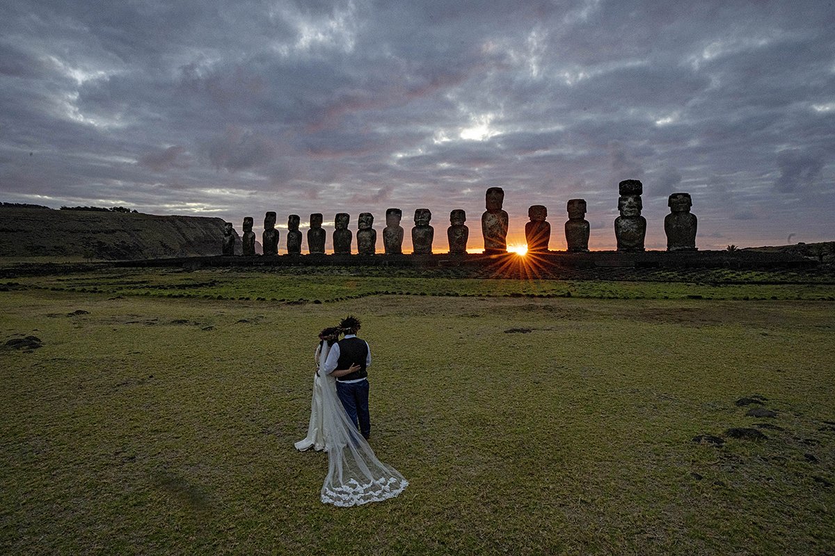 Молодожены из Чили фотографируются на фоне статуй моаи на восходе солнца