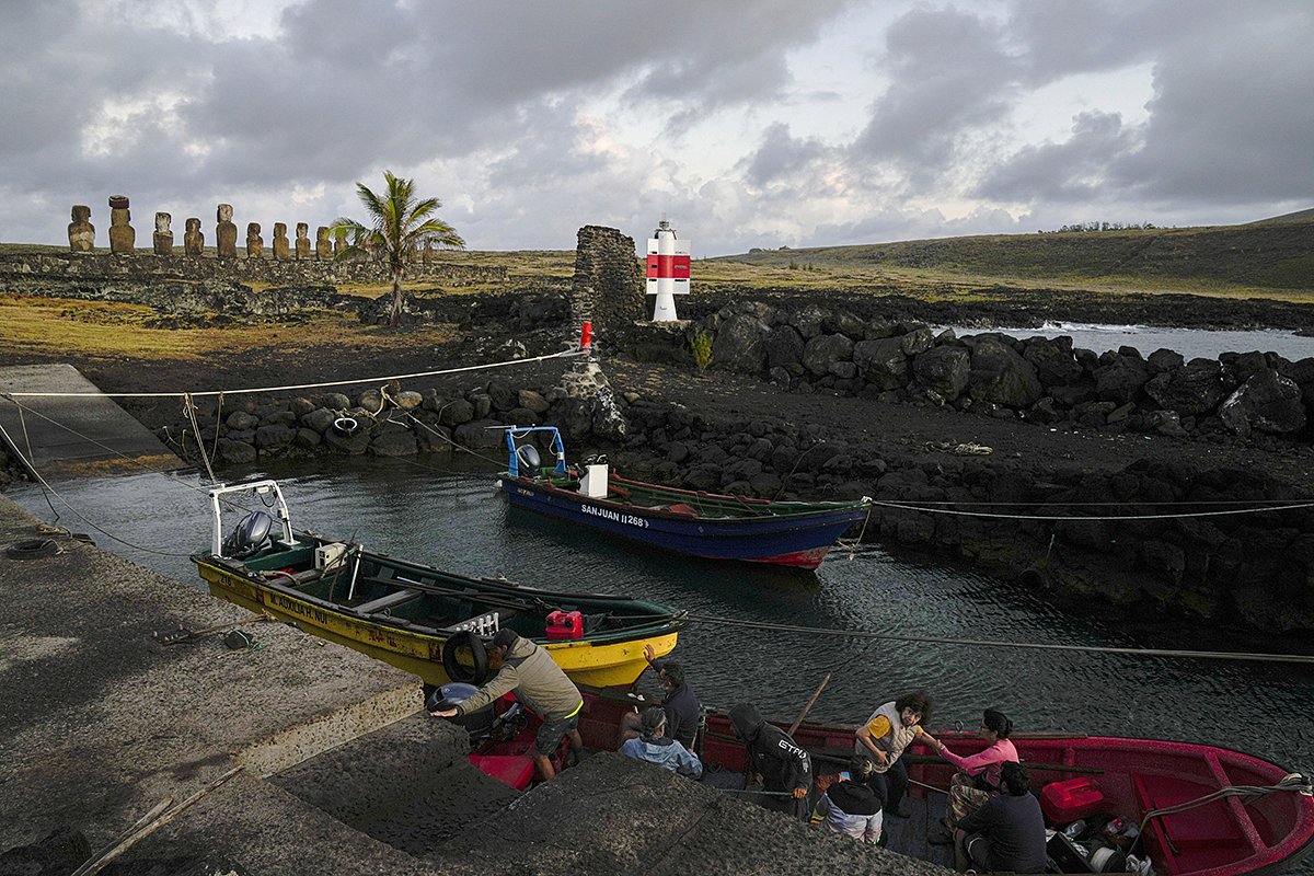 Местные рыбаки возят туристов на экскурсии на лодках, чтобы показать красоту побережья острова Пасхи