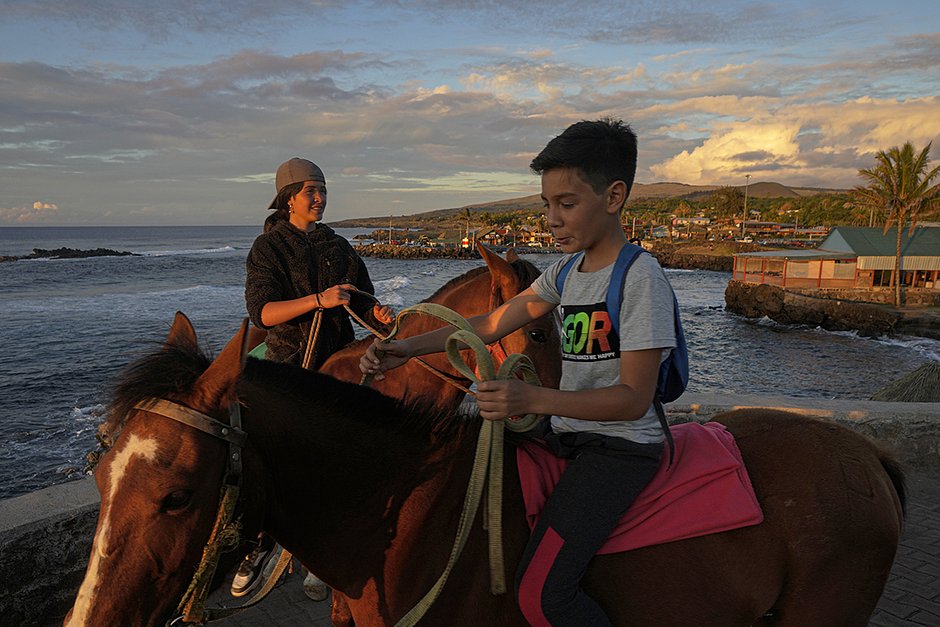 Местные студенты едут на лошадях по пляжу Анна-Роа