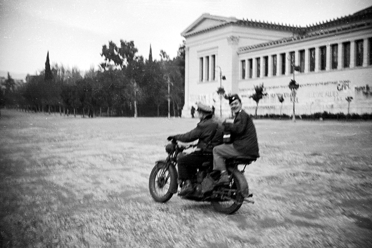 Американские военные на мотоцикле проезжают здание выставочного центра Заппейон в историческом центре города