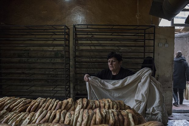 Женщина накрывает свежий хлеб в пекарне города Мартакерт (Адгере) в Нагорном Карабахе, 15 декабря 2020 года. Фото: Валерий Мельников / РИА Новости