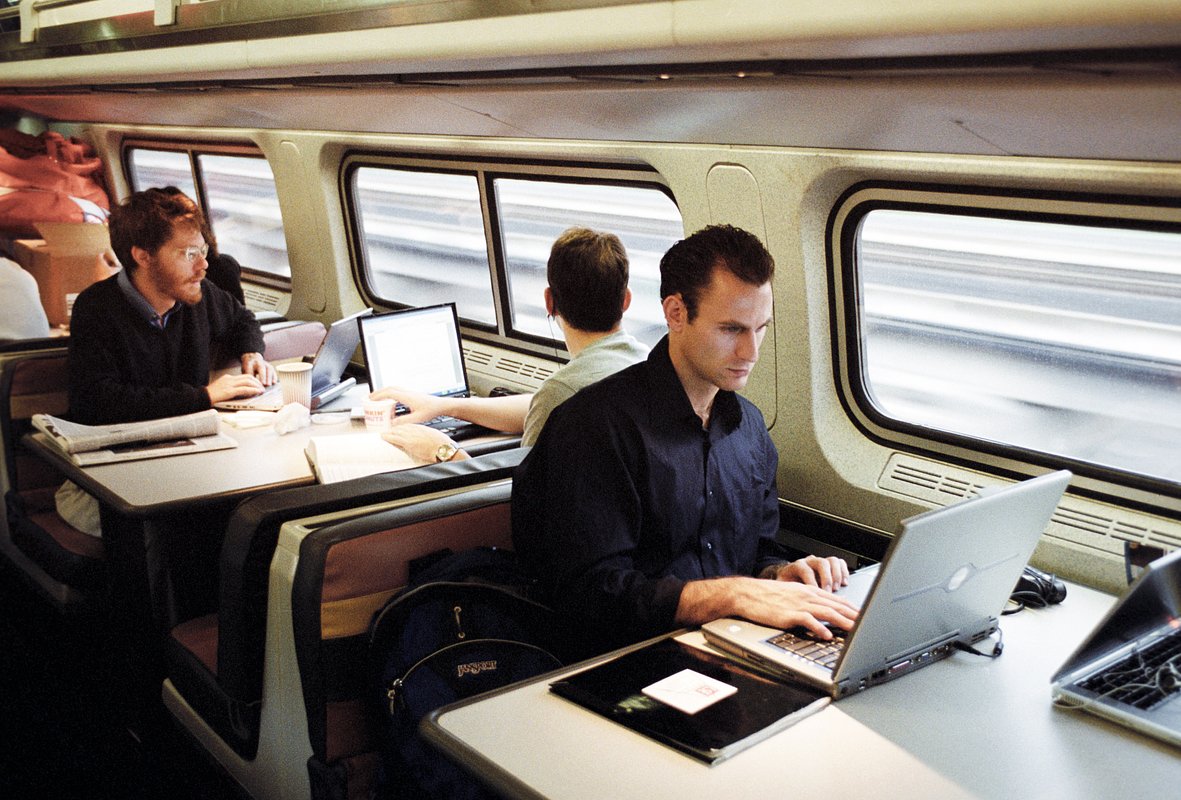 Вашингтон, США. Пассажиры работают с ноутбуками в поезде