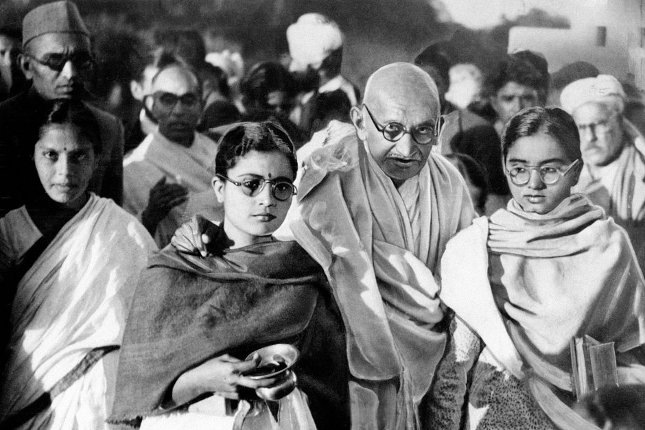 Махатма Ганди с ученицами, одна из которых несет медную чашу со святой водой, январь 1948 года