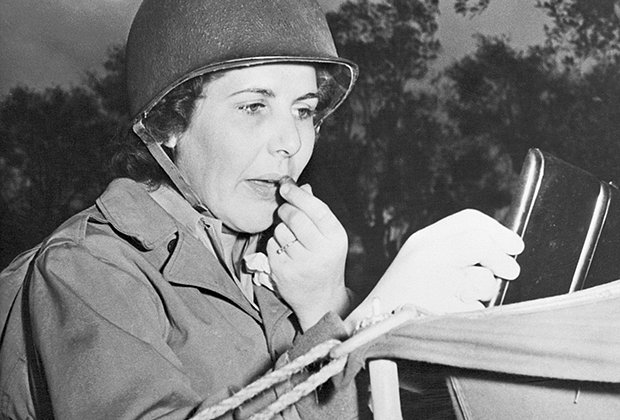 На фронте в Италии рядовая Лоис Леберт из Луизианы, США, наносит помаду возле своей палатки в годы Второй мировой войны