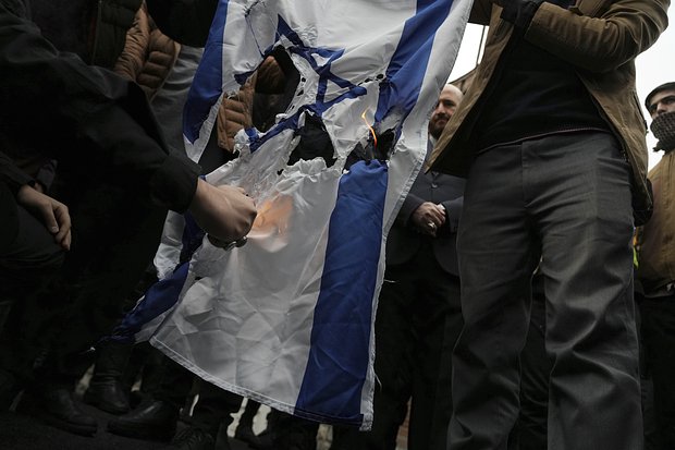 Иранские демонстранты сжигают израильский флаг во время протестов в январе 2023-го. Фото: Vahid Salemi / AP