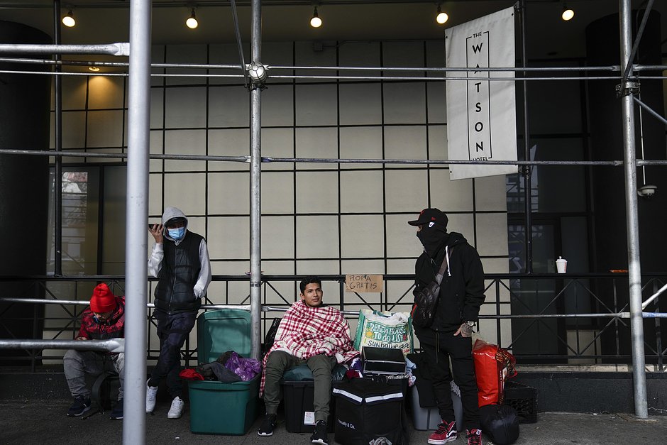 Новые мигранты в США стоят со своими вещами на тротуаре перед отелем «Уотсон» в Нью-Йорке, 30 января 2023 года