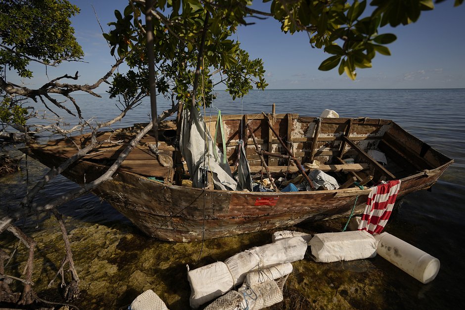 Деревянная лодка, использованная мигрантами, лежит на рифе рядом с мангровыми зарослями в Таверньере, штат Флорида, 19 января 2023 года