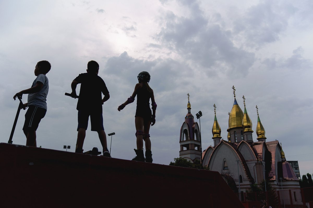 Дети в скейтпарке рядом с православной церковью в Днепре. 17 августа 2022 года
