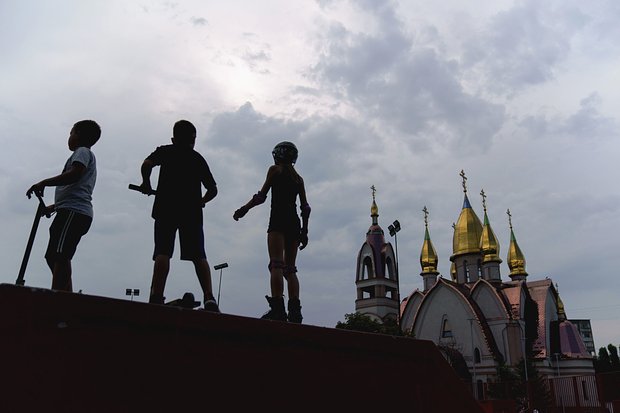Дети в скейтпарке рядом с православной церковью в Днепре. 17 августа 2022 года. Фото: David Goldman / AP