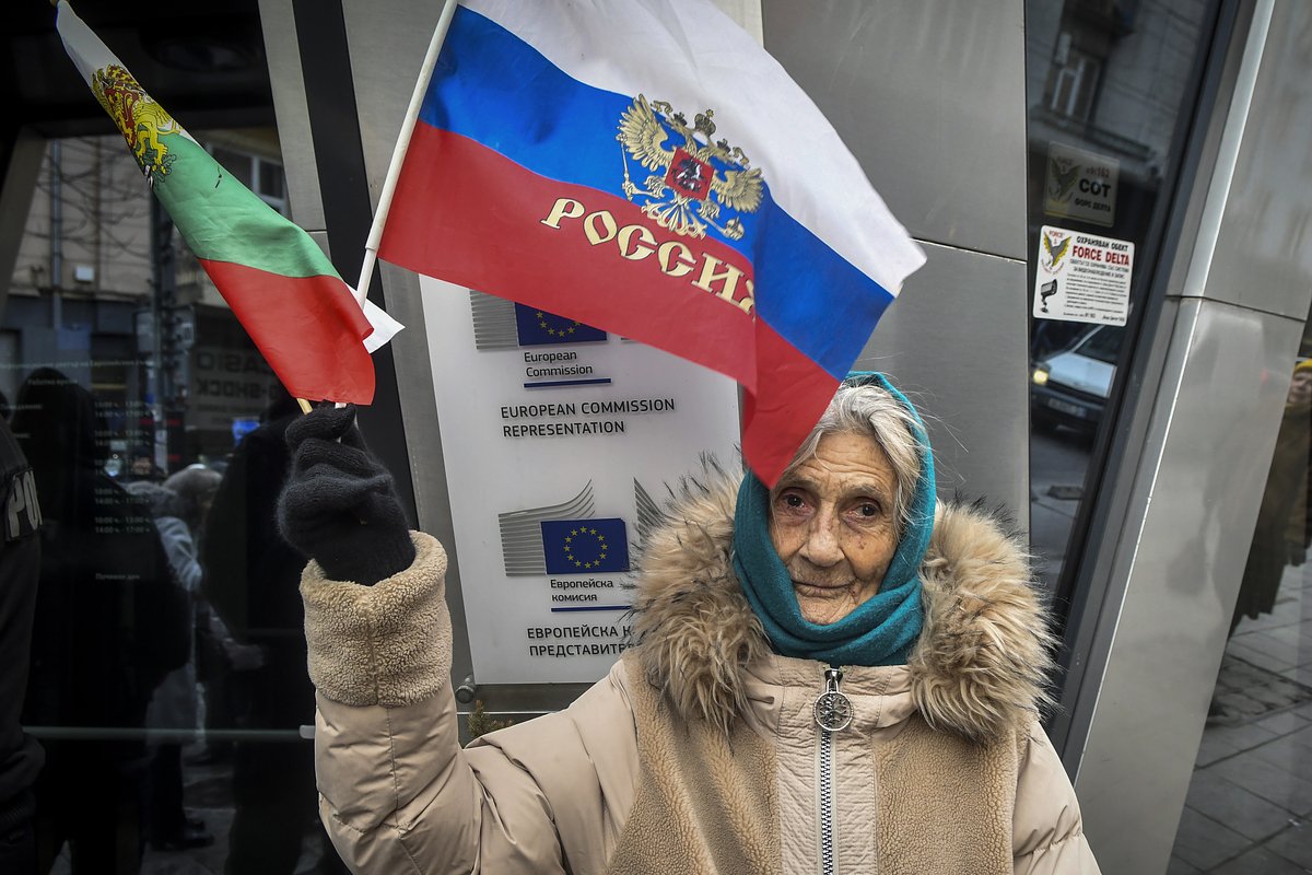Женщина с российским и болгарским флагами перед офисом Еврокомиссии во время акции протеста против запрета российских телеканалов в Болгарии. 7 февраля 2023 года