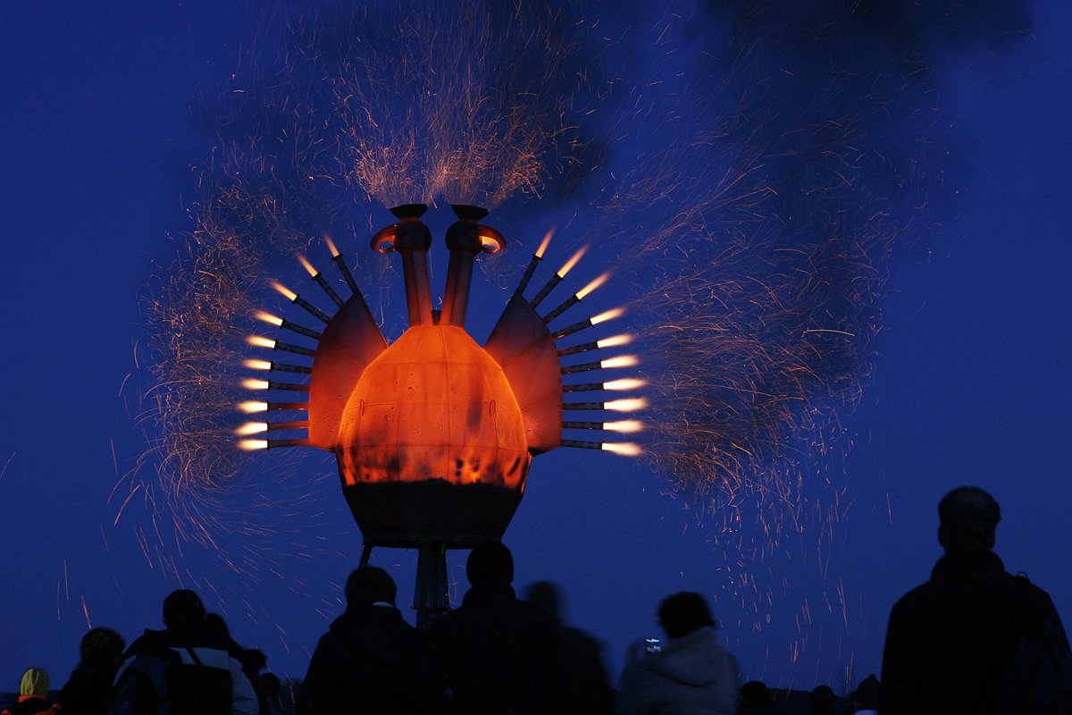 People watch a 'The Firebird' creation by Russian artist Nikolay Polissky during a celebration of the Pancake Week (Maslenitsa) at the artist's village of Nikola-Lenivets, some 200 km (124 miles) from Moscow March 8, 2008. Maslenitsa is the only purely Russian Holiday that dates back to the pagan times. 