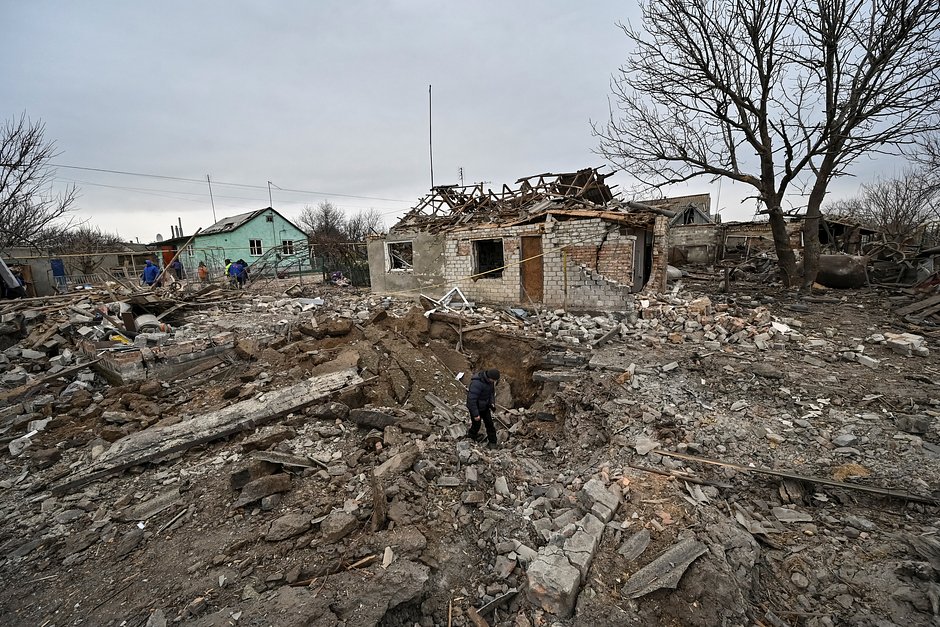 Местный житель осматривает воронку от снаряда, село Куприяновка, Запорожская область, 7 декабря 2022 года