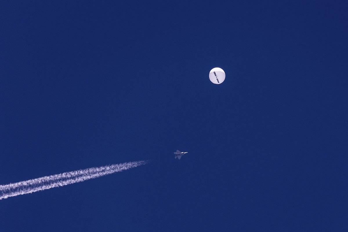 Истребитель пролетает рядом с большим воздушным шаром, дрейфующим над Атлантическим океаном недалеко от побережья Южной Каролины, 4 февраля 2023 года