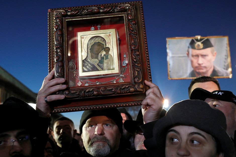 Мужчина держит икону Девы Марии на пути к храму Святого Саввы в Белграде, Сербия, 17 января 2019 года