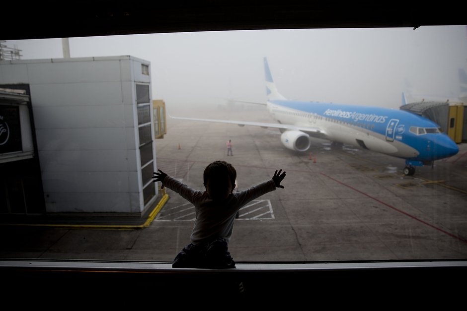 Ребенок наблюдает за самолетом в аэропорту Хорхе Ньюбери в Буэнос-Айресе, 14 апреля 2016 года