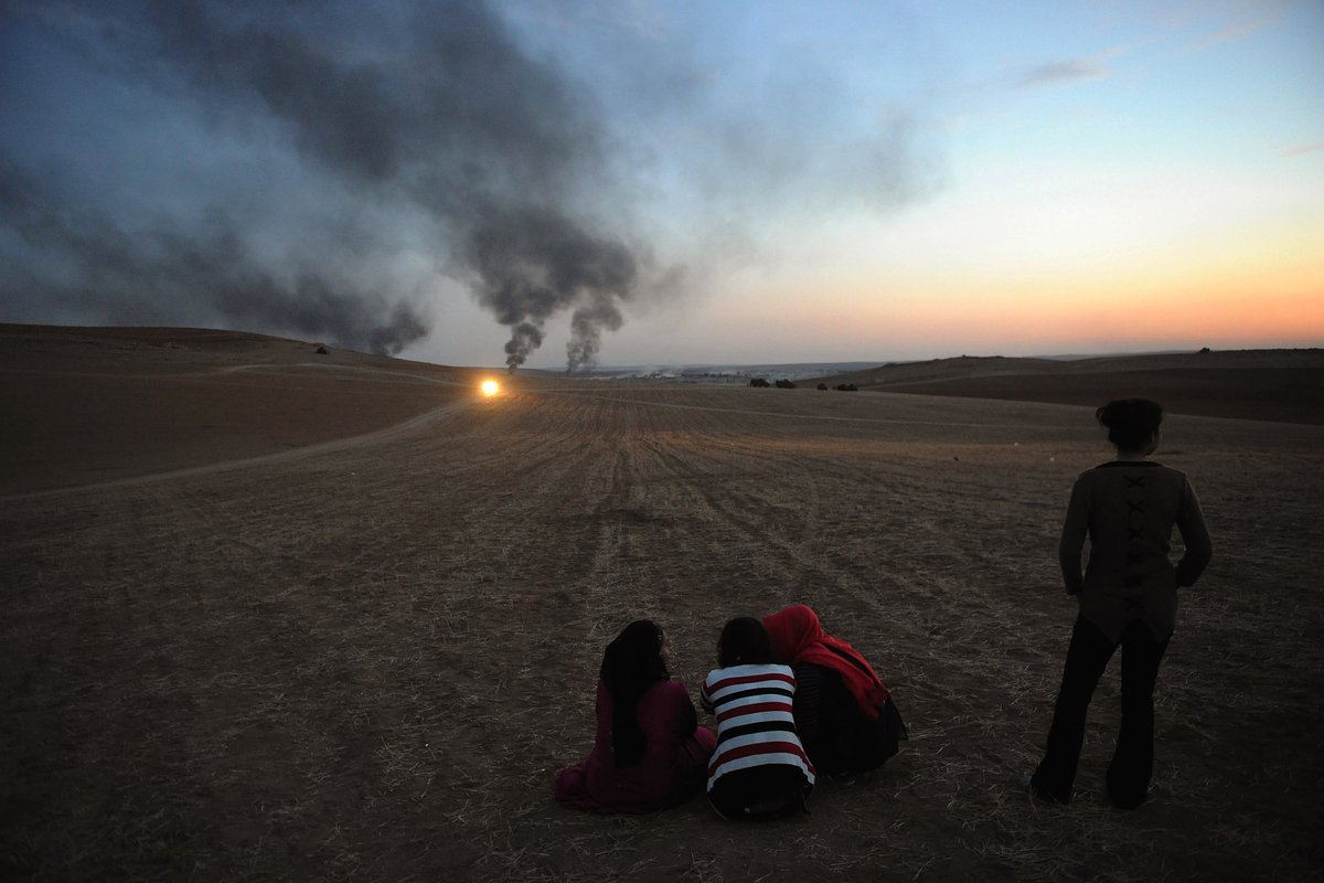 Густой дым над сирийским городом Кобани, возникший из-за столкновения между боевиками ИГ и курдскими Отрядами народной самообороны (YPG), турецко-сирийская граница в Шанлыурфе, 26 октября 2014 года