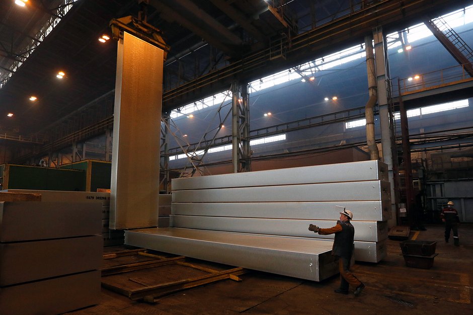 Сотрудники предприятия управляют погрузчиком для транспортировки 13-метрового алюминиевого слитка весом 34 тонны в литейном цехе Красноярского алюминиевого завода «РУСАЛ»