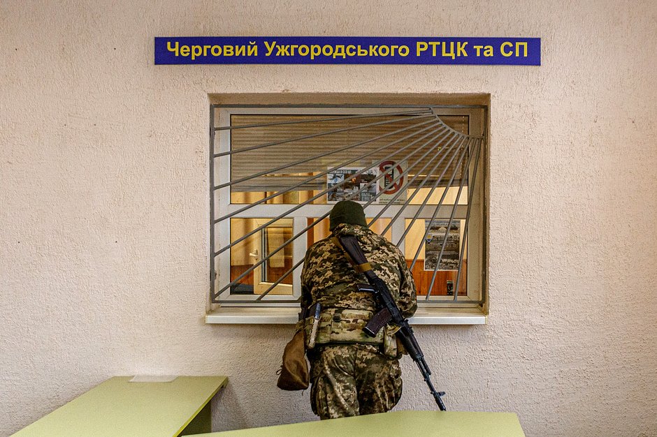 Вооруженный мужчина в камуфляжной форме у Закарпатского областного территориального центра кадрового и социального обеспечения, Ужгород, Закарпатская область, 25 февраля 2022 года